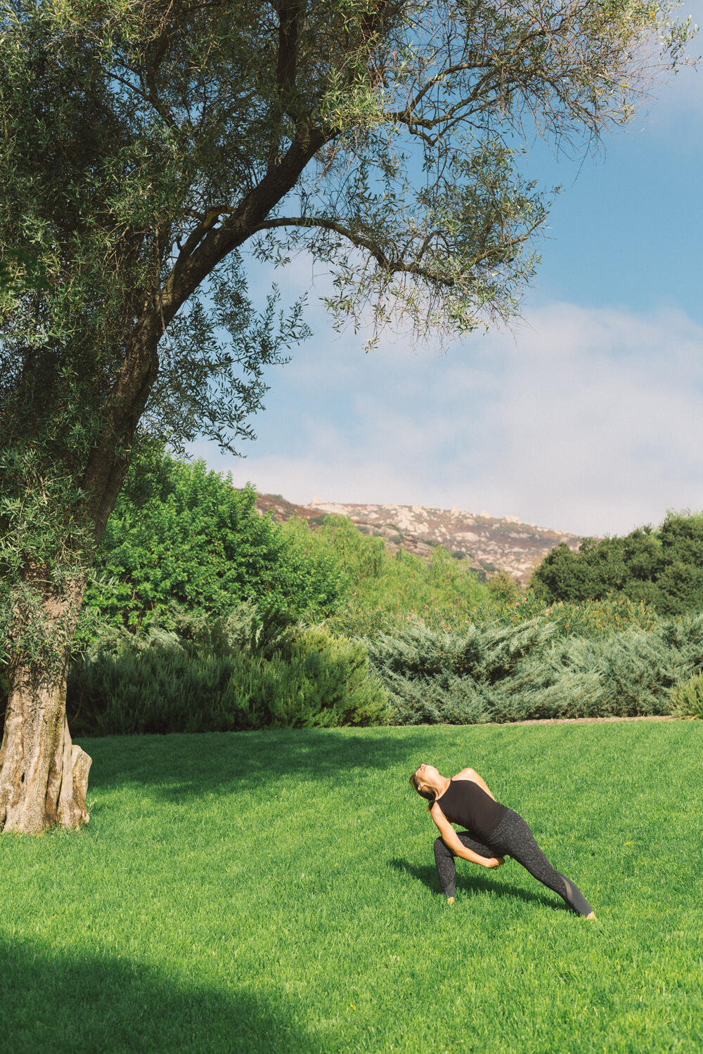 Woman doing yoga in grassy field